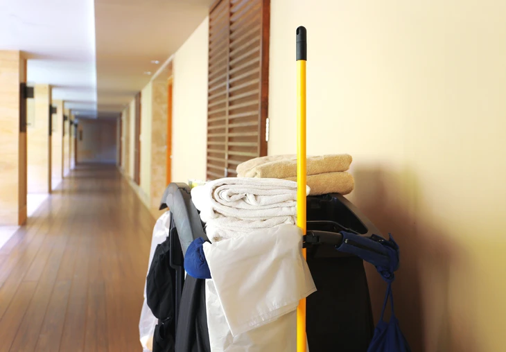 Couloir d'hôtel moderne avec chariot de ménage professionnel stationné contre le mur