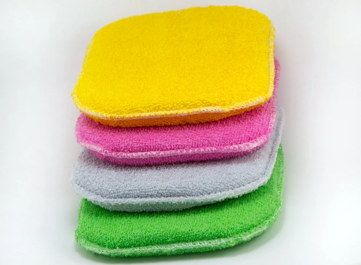 Pile de quatre chiffons microfibres colorés empilés sur fond blanc neutre