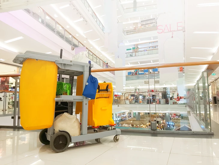 Intérieur d'un centre commercial moderne avec chariot de nettoyage professionnel au premier plan