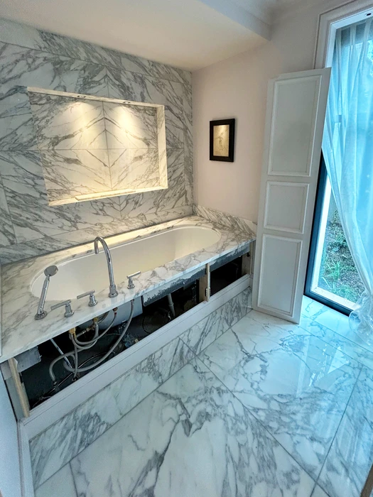 Salle de bains luxueuse en cours de finition, baignoire encastrée en îlot sur plateforme