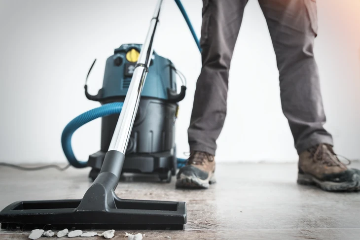 Équipe de nettoyage professionnel en uniformes verts travaillant dans un espace commercial moderne